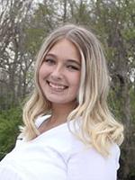 Blonde girl with blue eyes smiling wearing white shirt